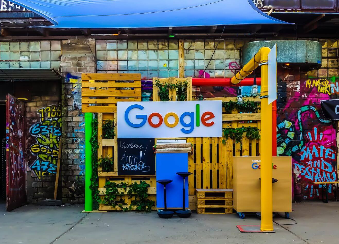 Colorful Google display with a wooden backdrop, surrounded by graffiti-covered walls.